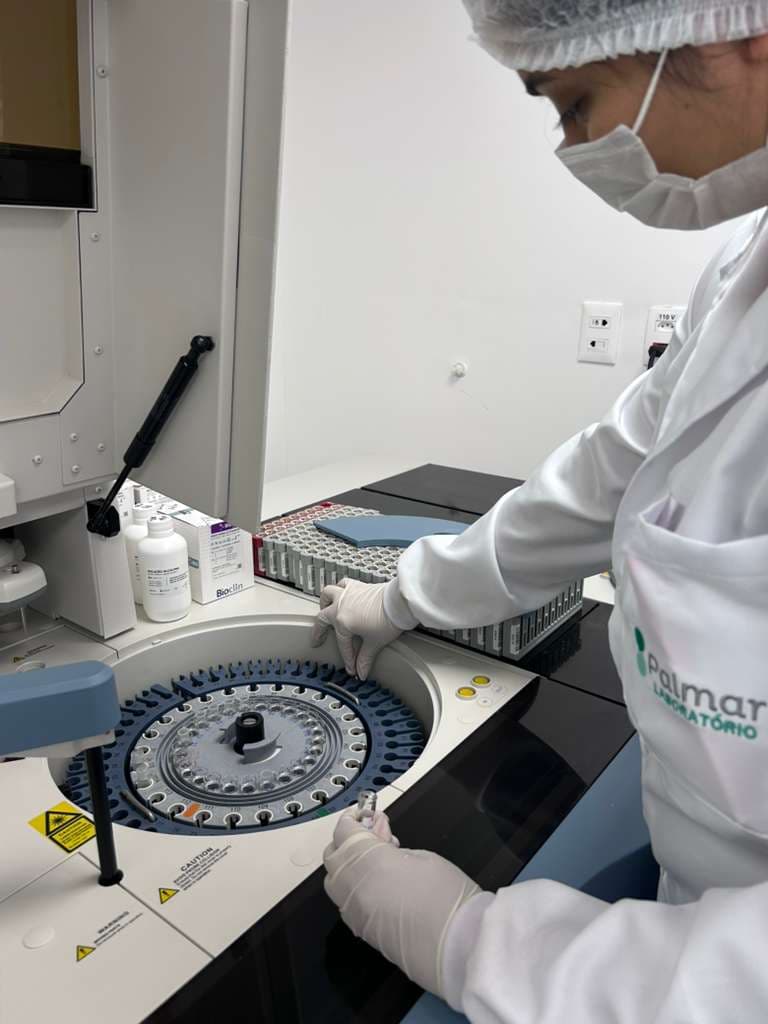 Profissional do Laboratório Palmar operando equipamento automatizado de análises